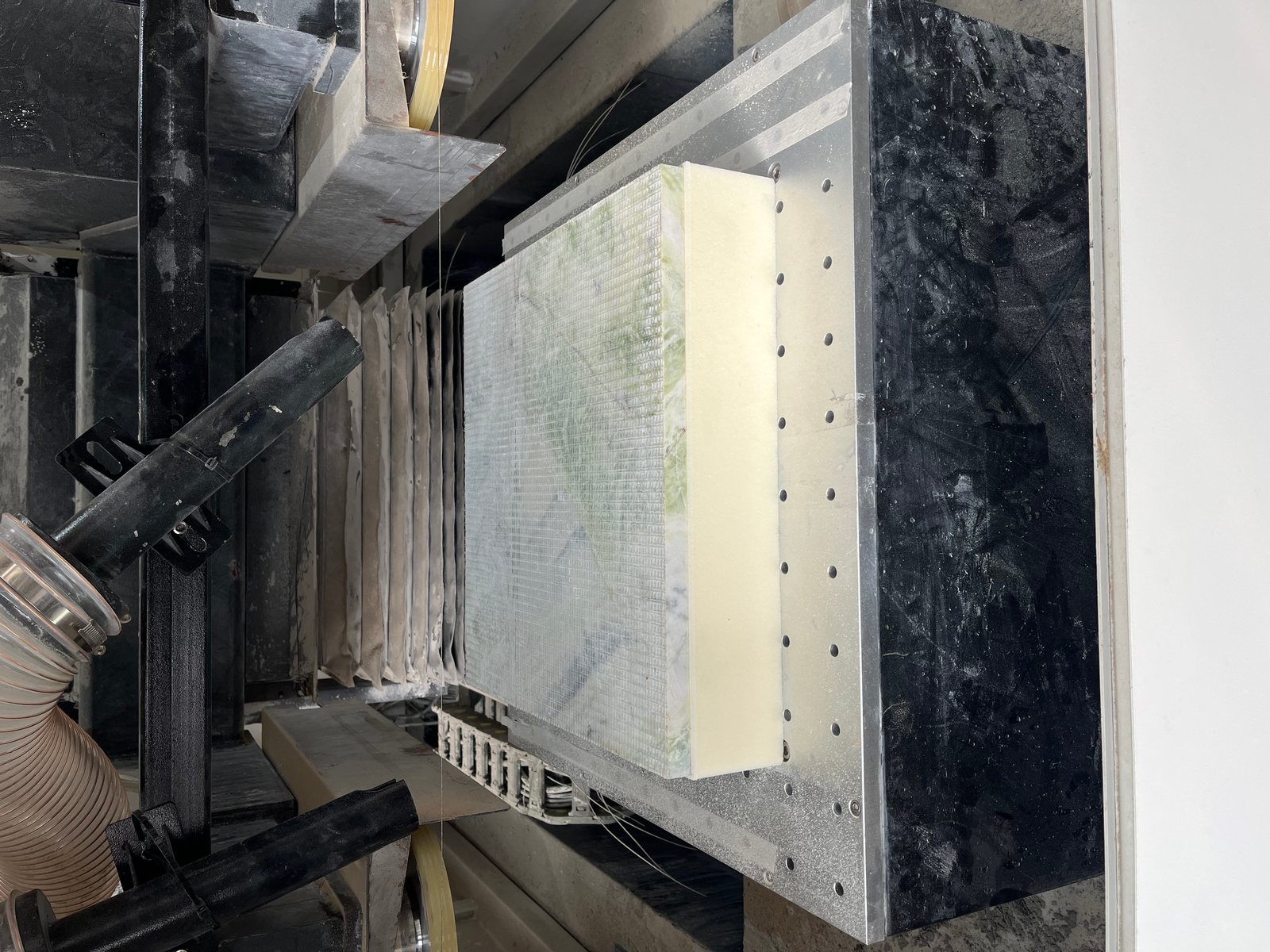 PMI foam block mounted on the fixture being sliced by a horizontal diamond wire loop